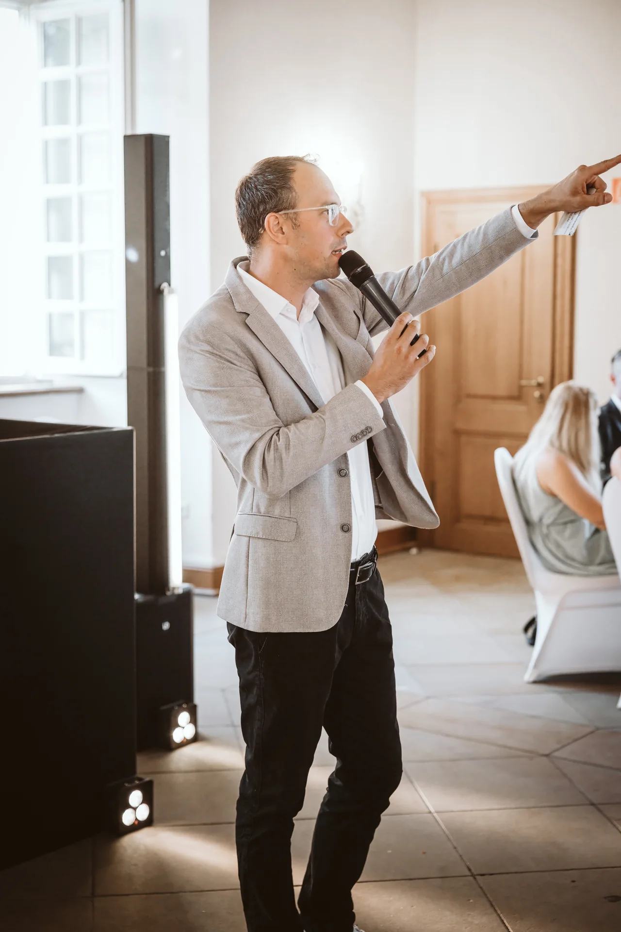 René Kaffée moderiert mit Mikrofon bei einer Veranstaltung