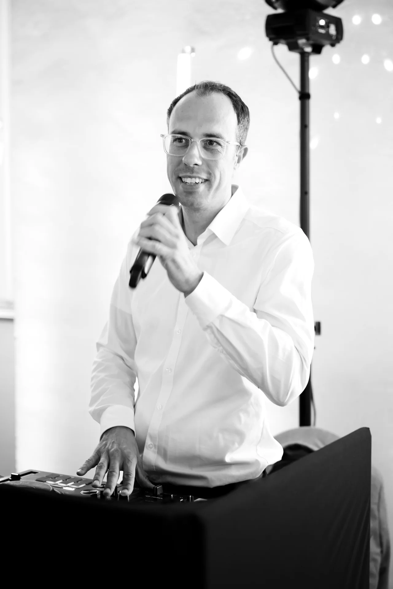René Kaffée moderiert am DJ-Pult mit einem Mikrofon